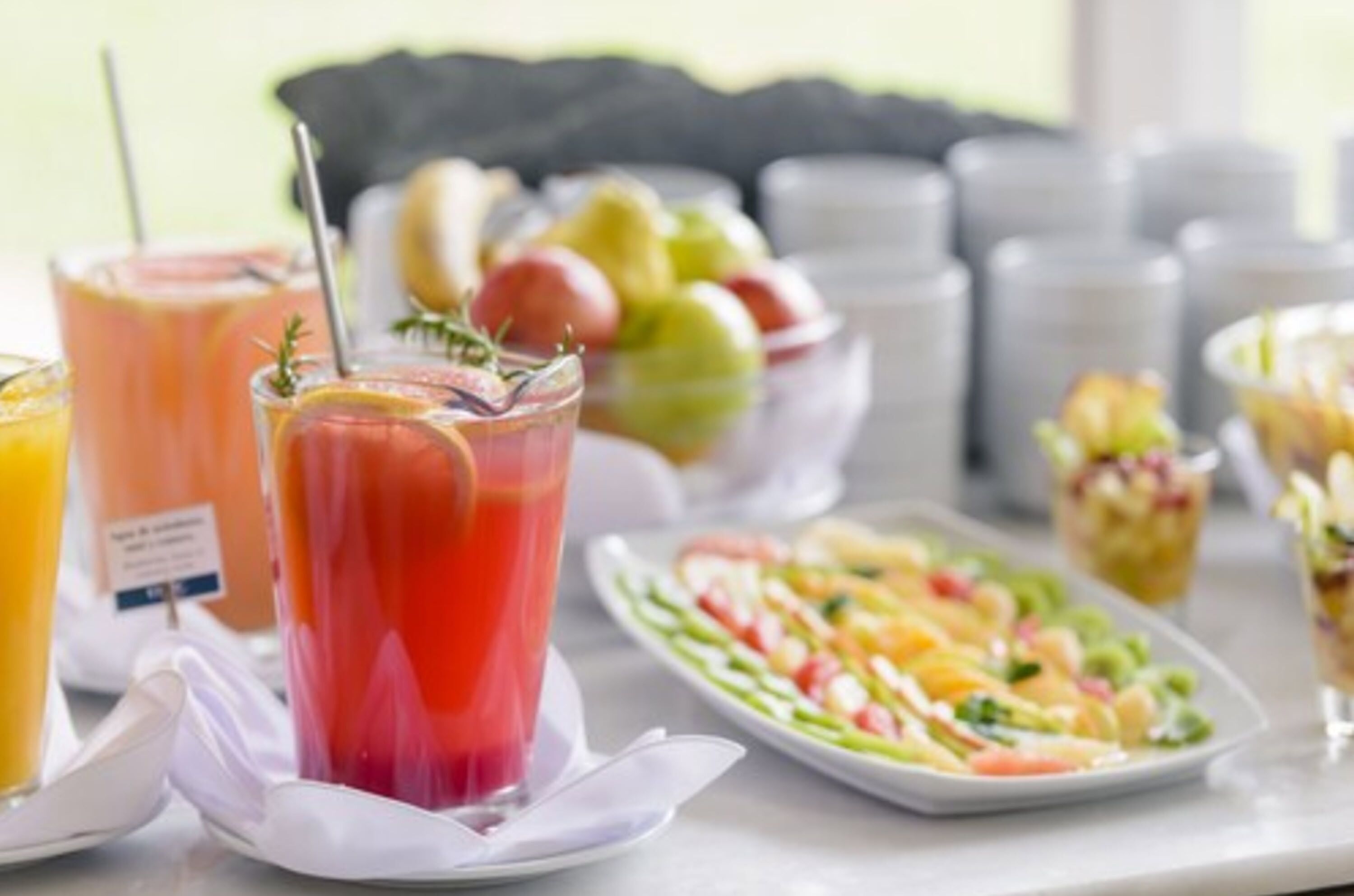 A breakfast buffet with various drinks and a salad.