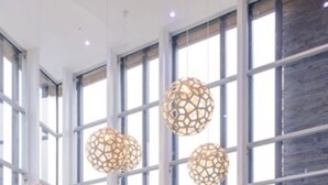 A spacious room with large windows, a blue sofa, and hanging spherical light fixtures. - Epic Hotel Villa de Merlo (Merlo)