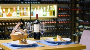 A dining table with plates of food, wine glasses, and a bottle of wine. - Epic Hotel Villa de Merlo (Merlo)