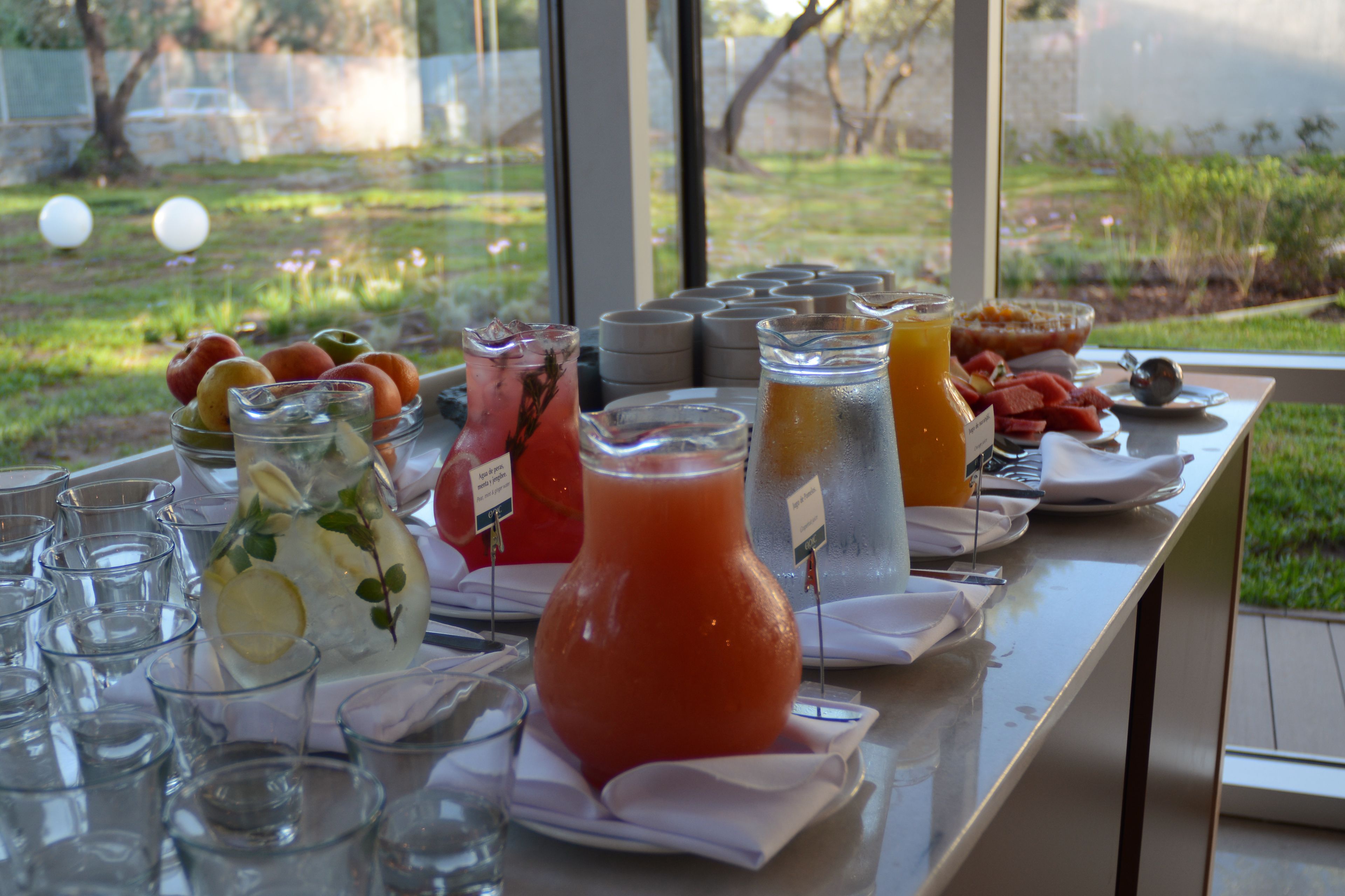A buffet table with various beverages and fruits.