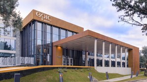 A modern hotel with a prominent 'Epic Hotels' sign, large glass windows, and a covered entrance area. - Epic Hotel Villa de Merlo (Merlo)