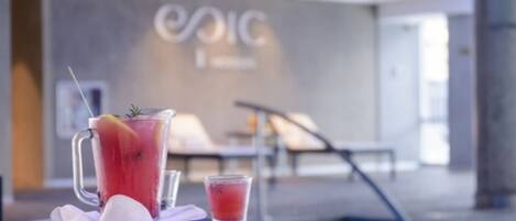 A poolside area with a drink, a lounge chair, and a wall with the text "EPCIC".