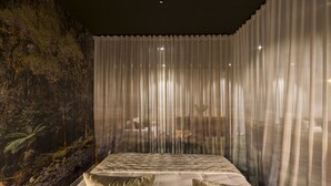 A bedroom with a bed, a mural on the wall, and sheer curtains. - The Cinema Suites (Te Anau)