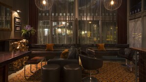 A modern interior with a seating area, large windows, and a bar. - The Cinema Suites (Te Anau)