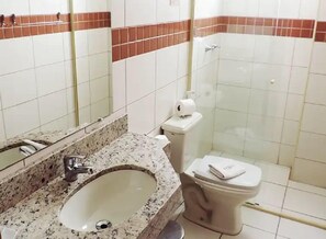 Un baño con lavamanos, inodoro y ducha.