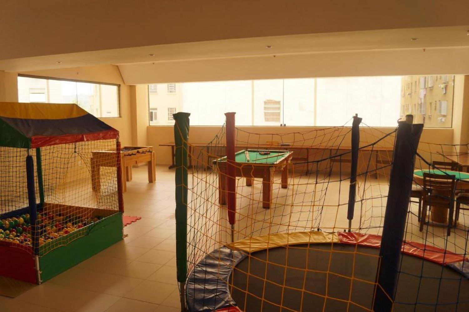 A play area with a ball pit, a trampoline, and a pool table.