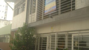 A building with barred windows and a sign on the wall. - Pousada Mar e Sol (Recife)
