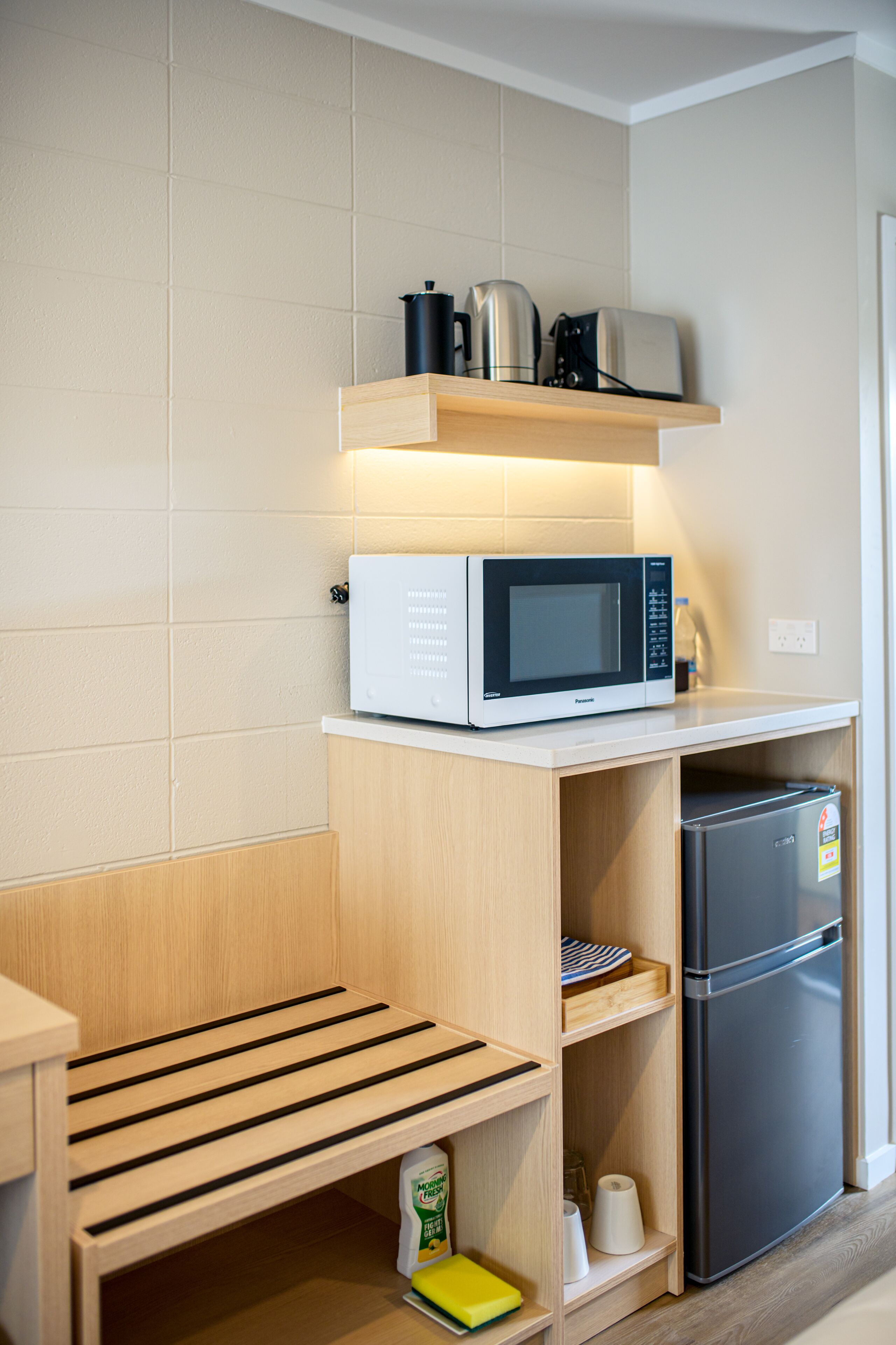 A compact kitchen with a microwave, toaster, and refrigerator.
