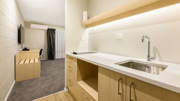 A modern kitchen with a sink, wooden cabinets, and a countertop.