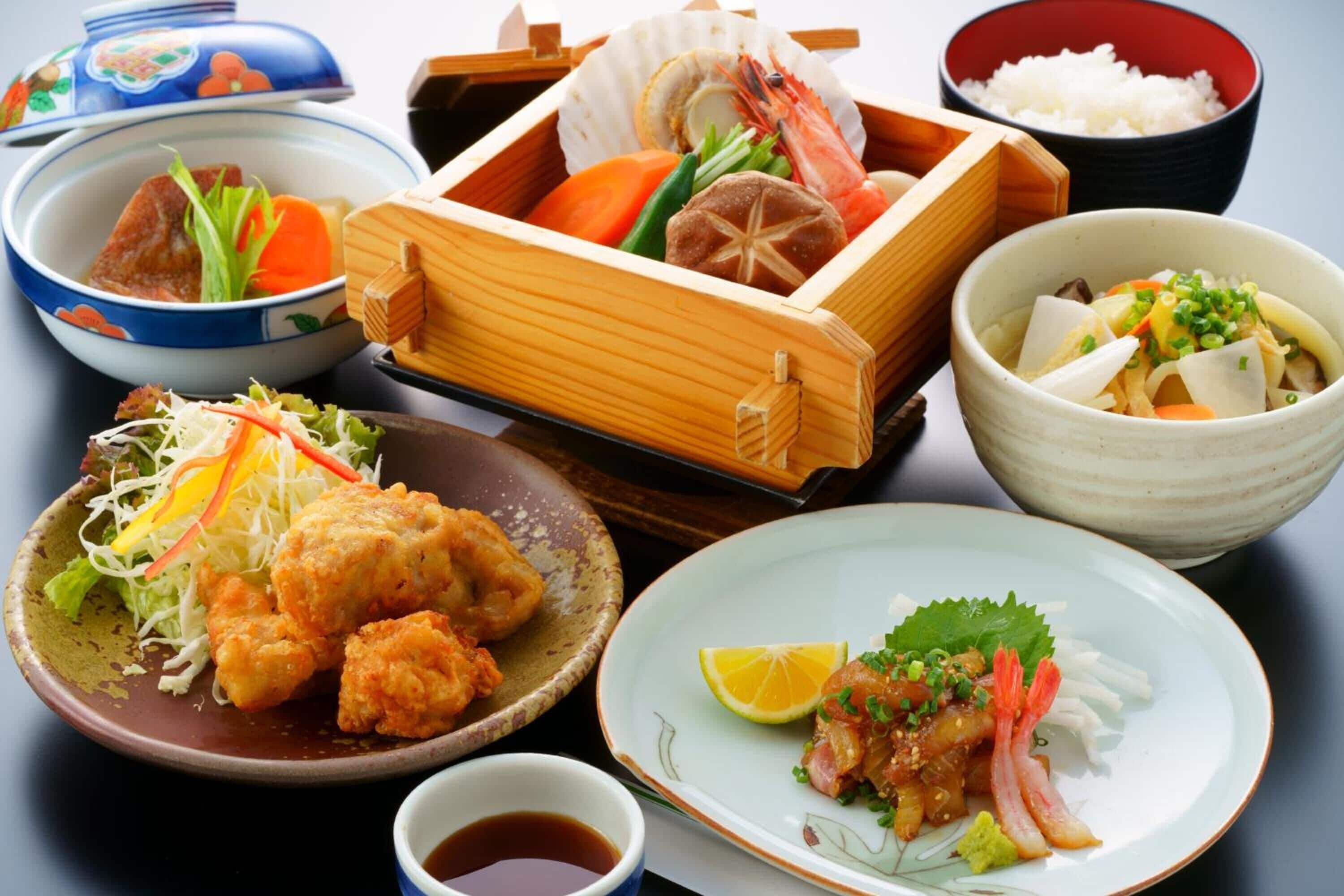 Ett urval av japanska rätter, inklusive sushi, tempura och en skål ris.