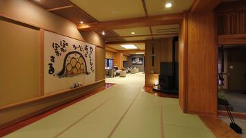 A traditional Japanese room with tatami flooring, a tatami mat display, and a wooden interior.