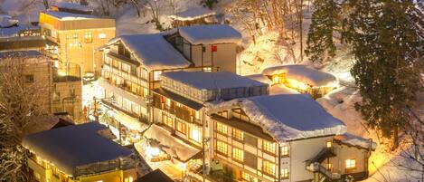 Un hotel cubierto de nieve con varias edificaciones, incluyendo un edificio principal con balcón y varias construcciones más pequeñas.