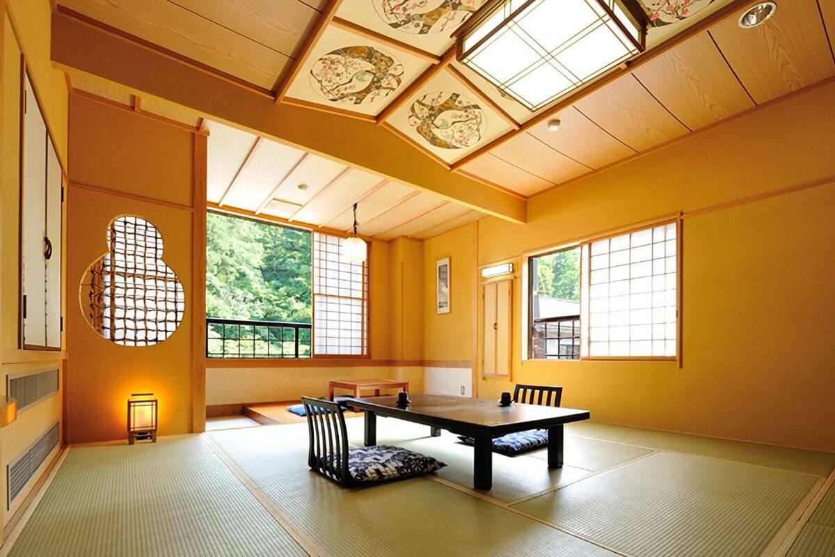 A traditional Japanese room with tatami flooring, a low table, and sliding doors.