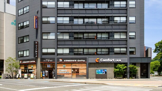 Ein modernes, mehrgeschossiges Gebäude mit flacher Fassade, im Erdgeschoss ein Comfort Inn Hotel.