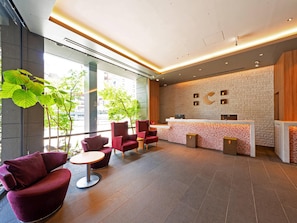A modern reception area with a stone wall, a reception desk, and seating.
