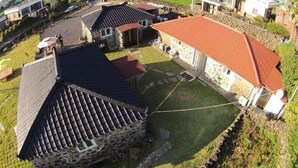 Una zona residencial con casas de piedra, un patio empedrado y un extenso campo abierto.