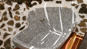 Un jacuzzi de paredes de piedra con revestimiento de mosaicos, piso de madera y un muro de piedra que lo rodea.