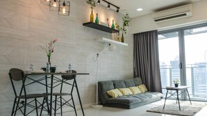 Un salon moderne comprenant un coin repas, un canapé, une table basse et une grande fenêtre avec des rideaux.