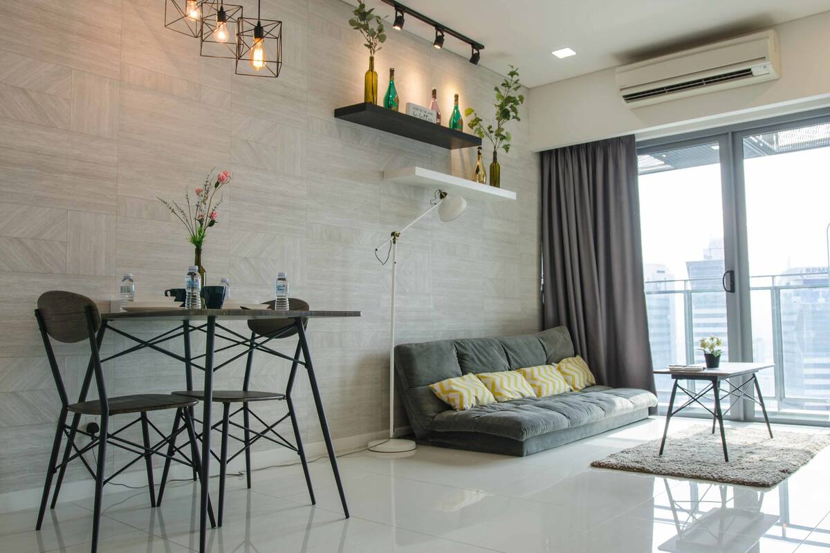 A modern living room with a dining area, a sofa, a coffee table, and a large window with curtains.