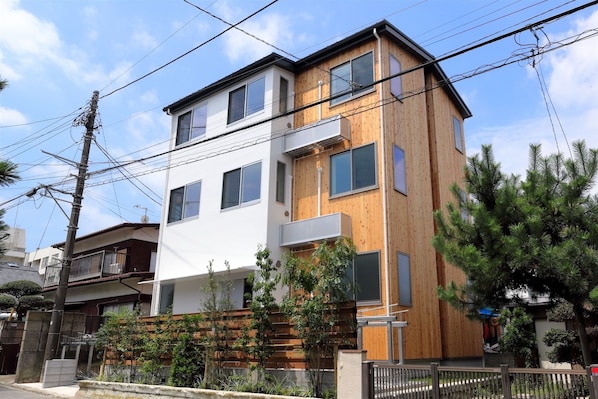 A modern two-story building with a wooden facade and white upper section.