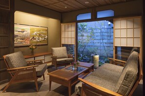 Una habitación tradicional japonesa con suelo de tatami, mesas de madera bajas y puertas correderas shoji.