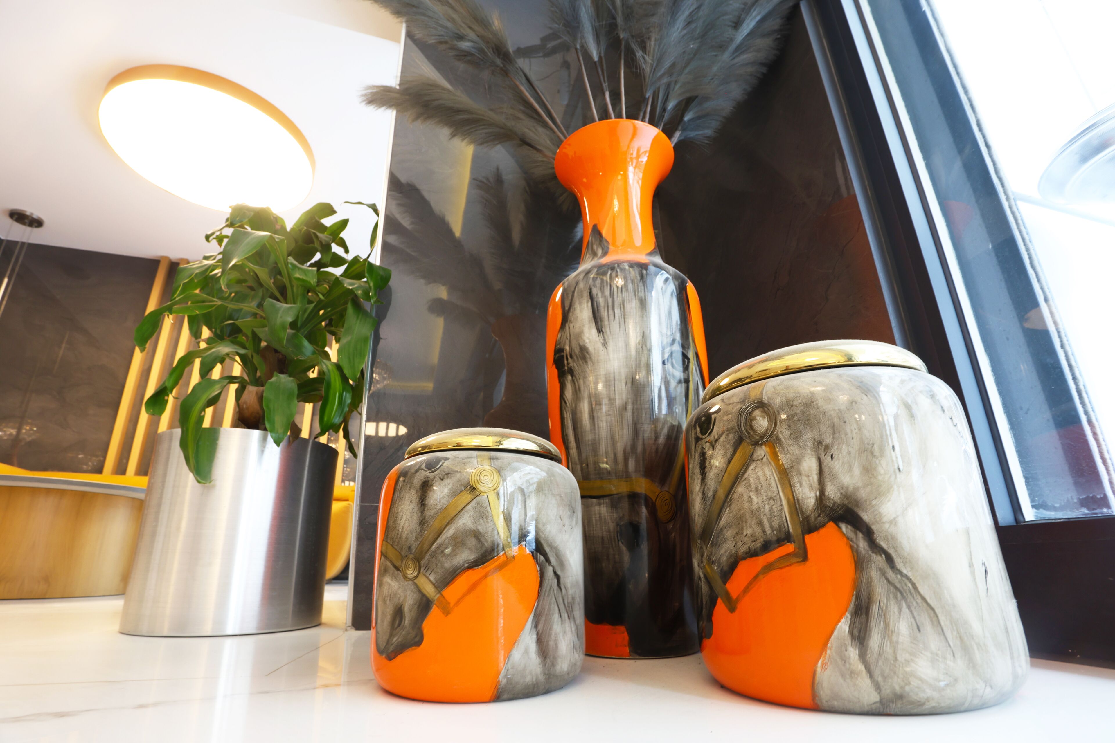 A modern interior with decorative vases and a potted plant.