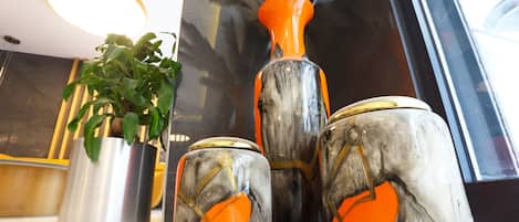 A modern interior with decorative vases and a potted plant.