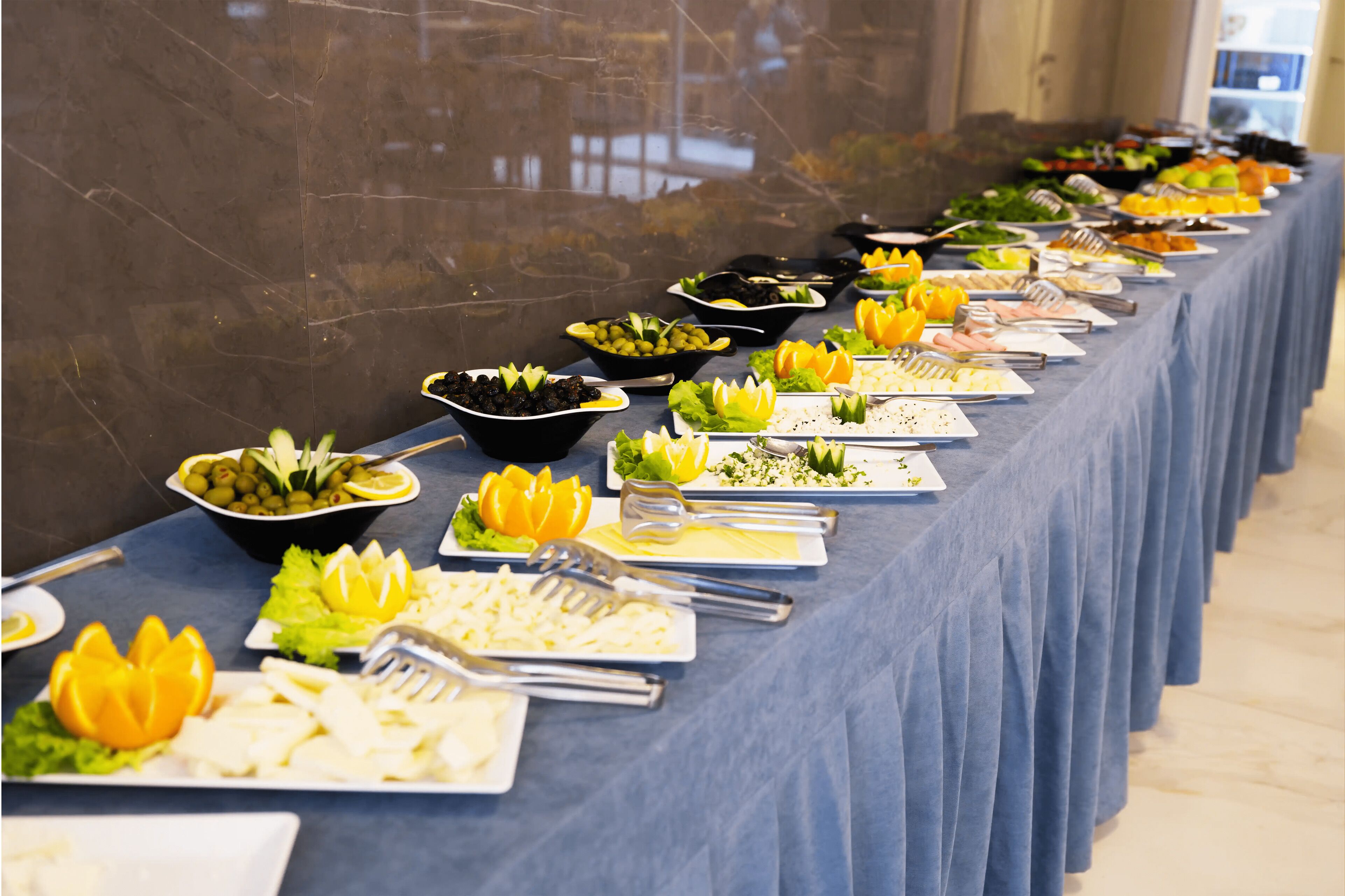 Een buffet met diverse gerechten en bestek.