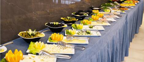 Una mesa de buffet con diversos alimentos y cubiertos.