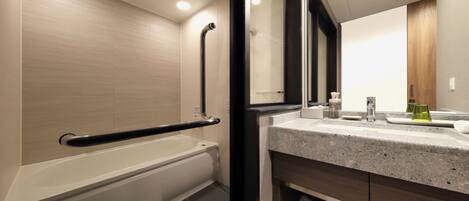 Ein modernes Badezimmer mit Badewanne, Dusche, Waschtisch mit Spiegel und Handtuchhalter.