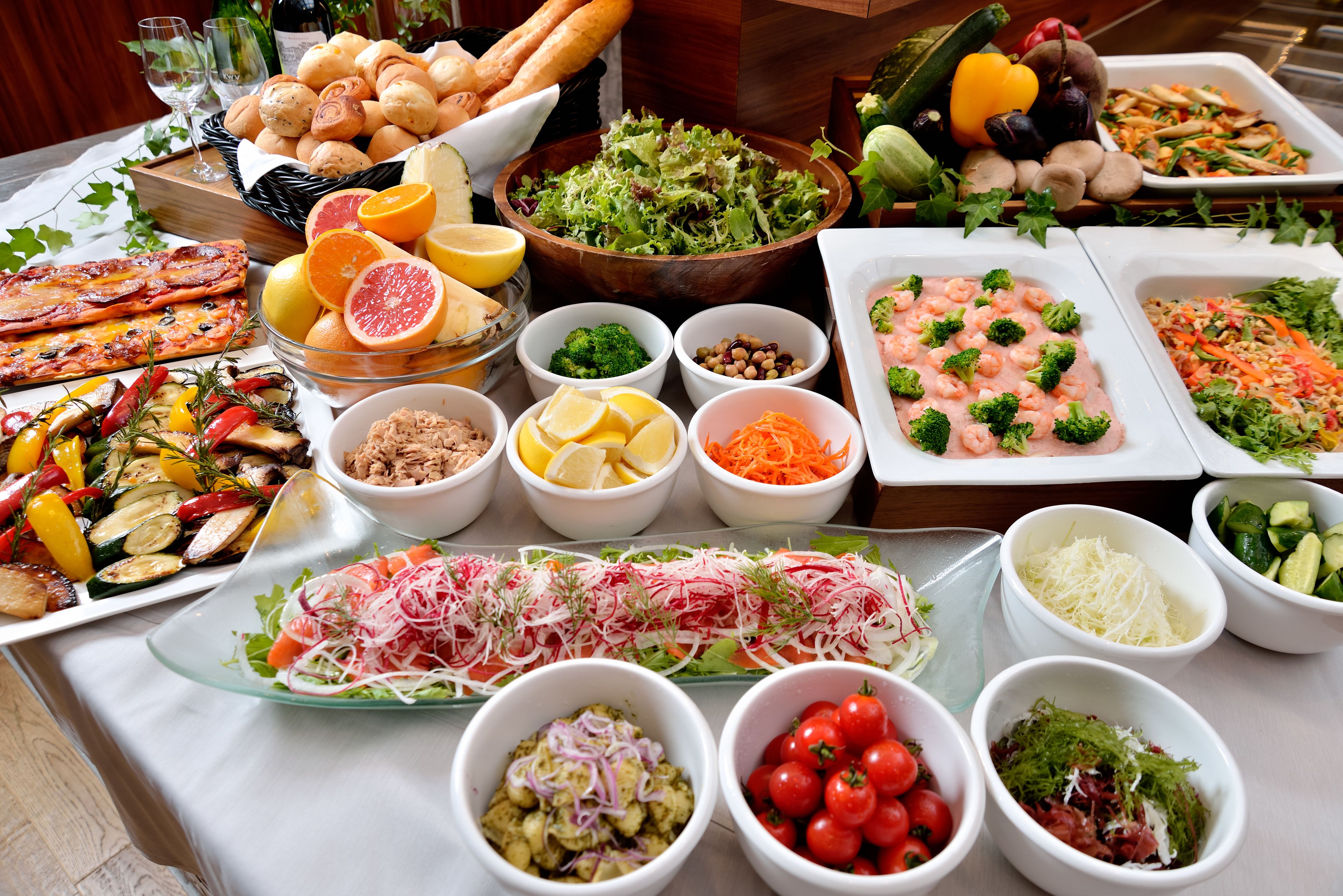 Un buffet proposant une variété de plats, notamment des salades, de la viande et des légumes.