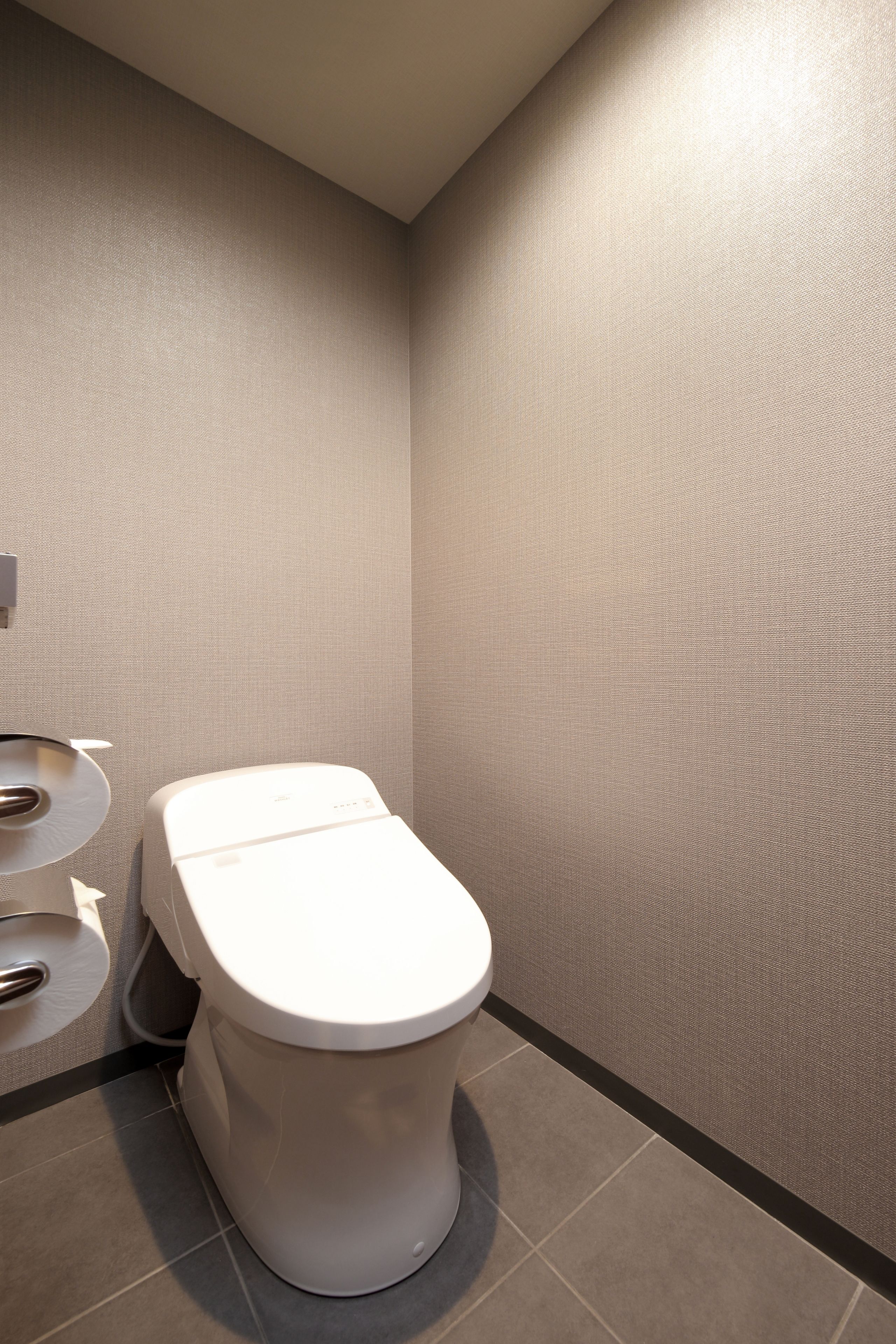 A modern bathroom with a toilet, sink, and mirror.