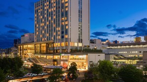 A modern hotel with multiple floors, a prominent entrance, and a visible parking area.