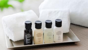 A tray with four bottles of John Masters Organics body wash and a white towel.
