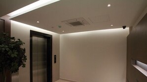 A modern elevator with a control panel and a wall-mounted security camera. - Tai Ichi Hotel (Kuala Lumpur)