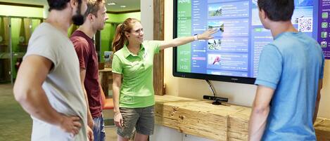 Un grupo de personas interactuando con una pantalla digital en un ambiente moderno.