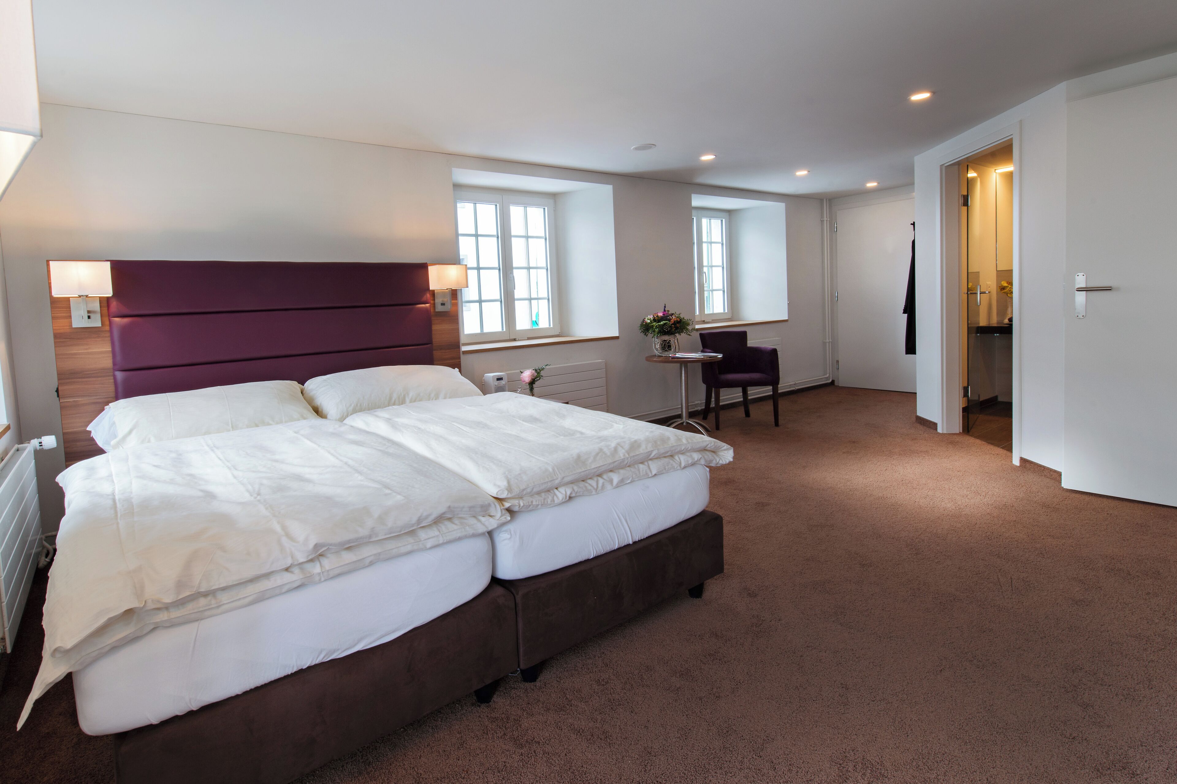 Habitación de hotel con una cama grande, un escritorio y una silla.