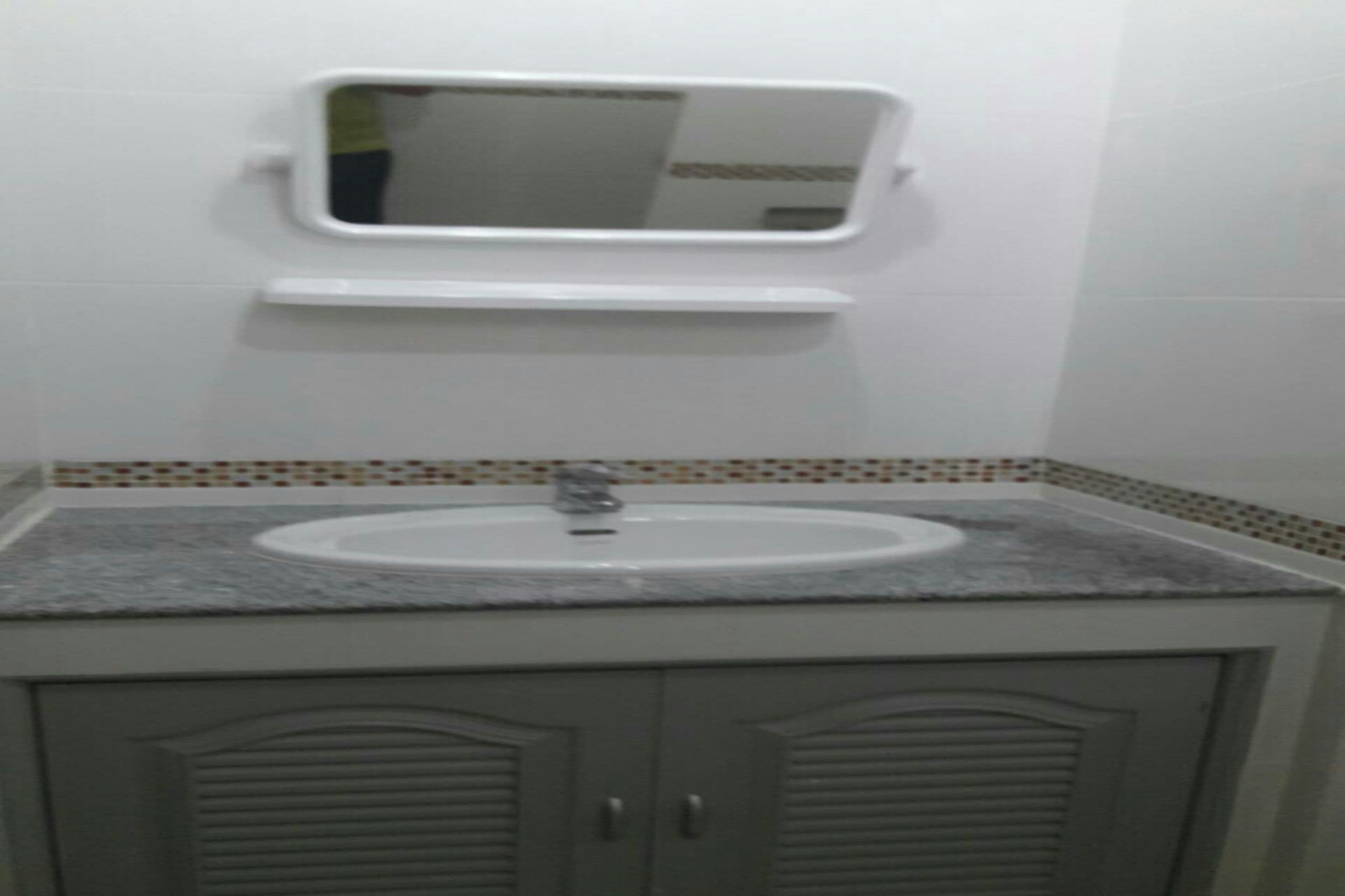 A bathroom with a sink, mirror, and tiled backsplash.