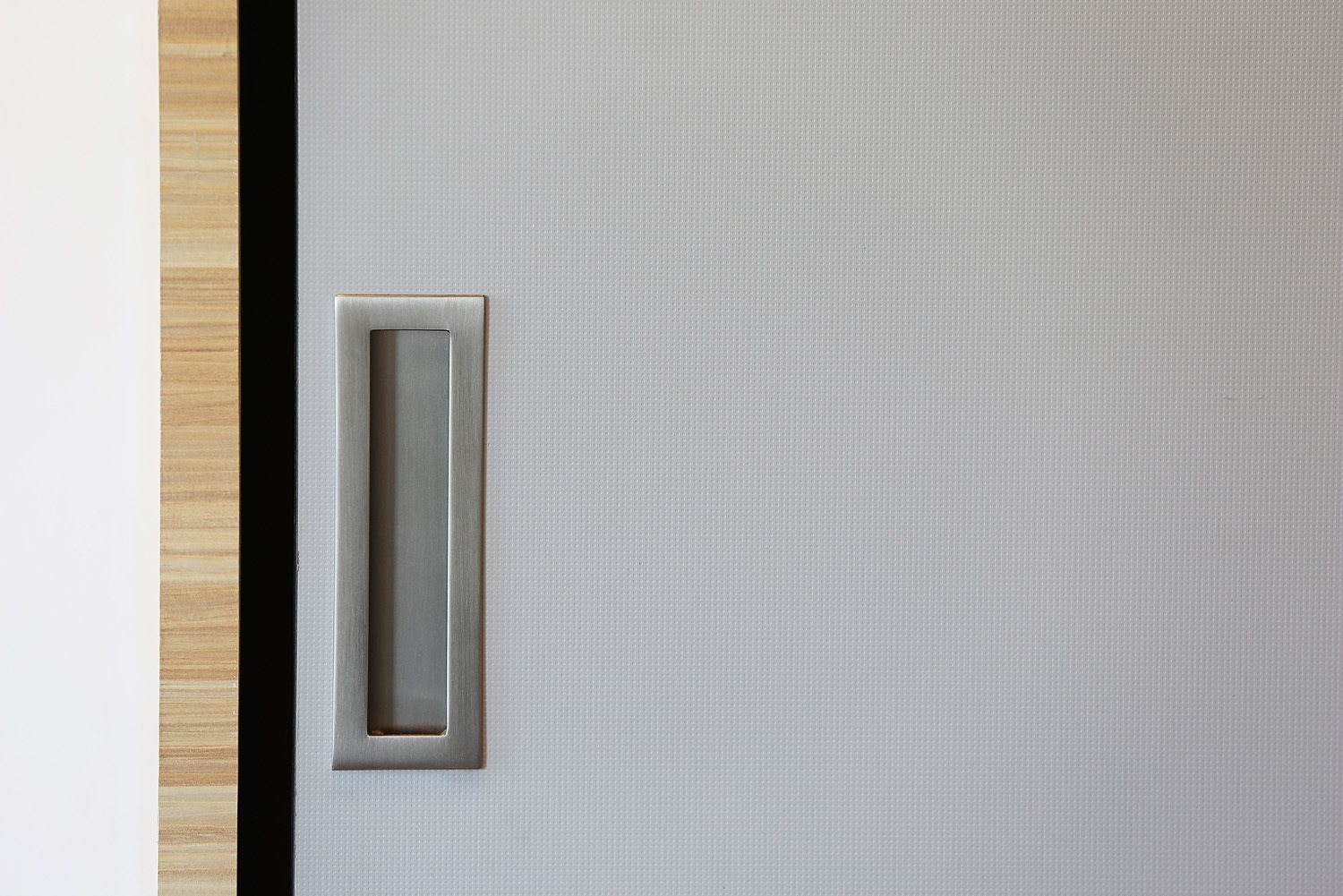 A door with a metallic handle and a textured surface.