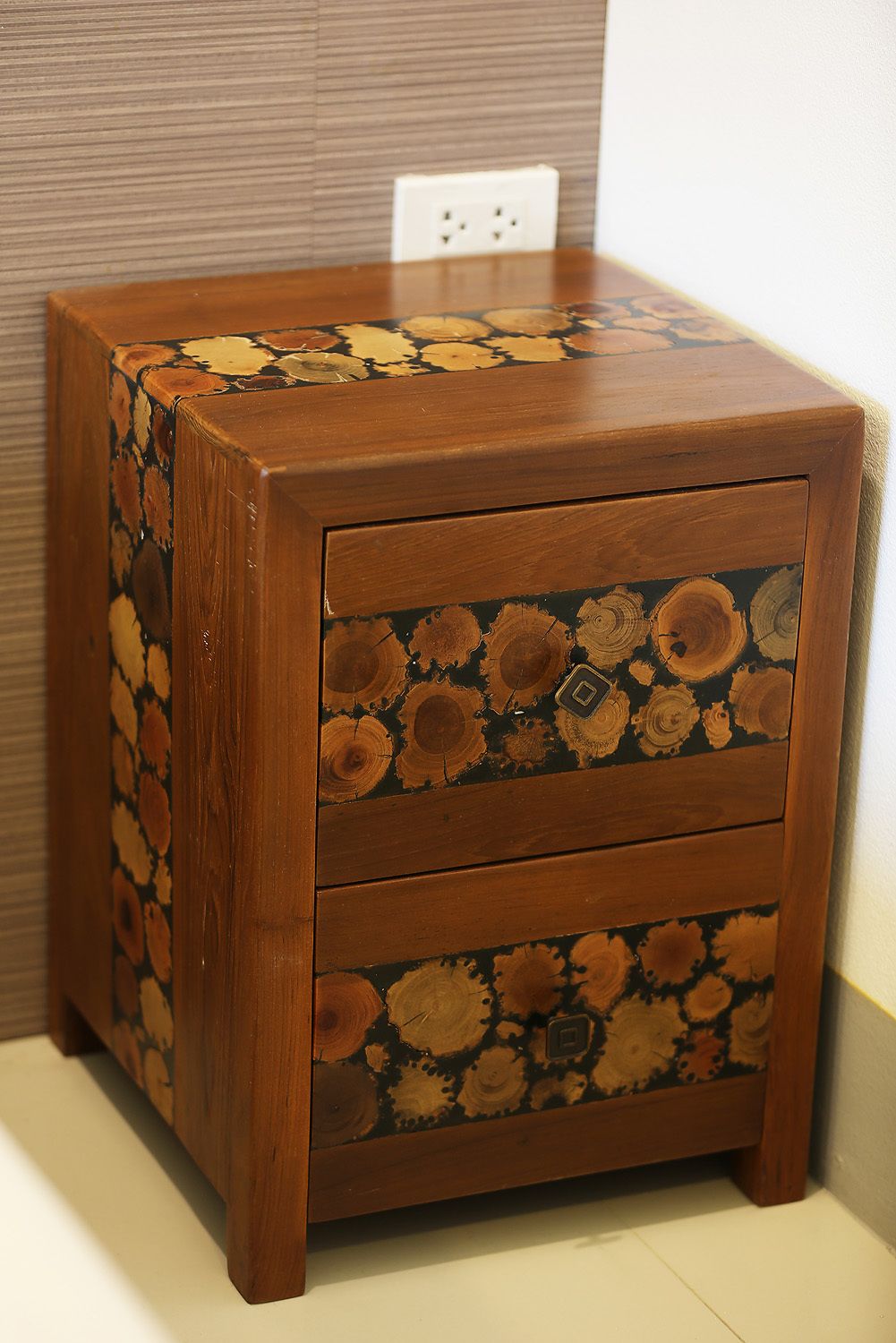 A wooden nightstand with a unique wood grain design and two drawers.