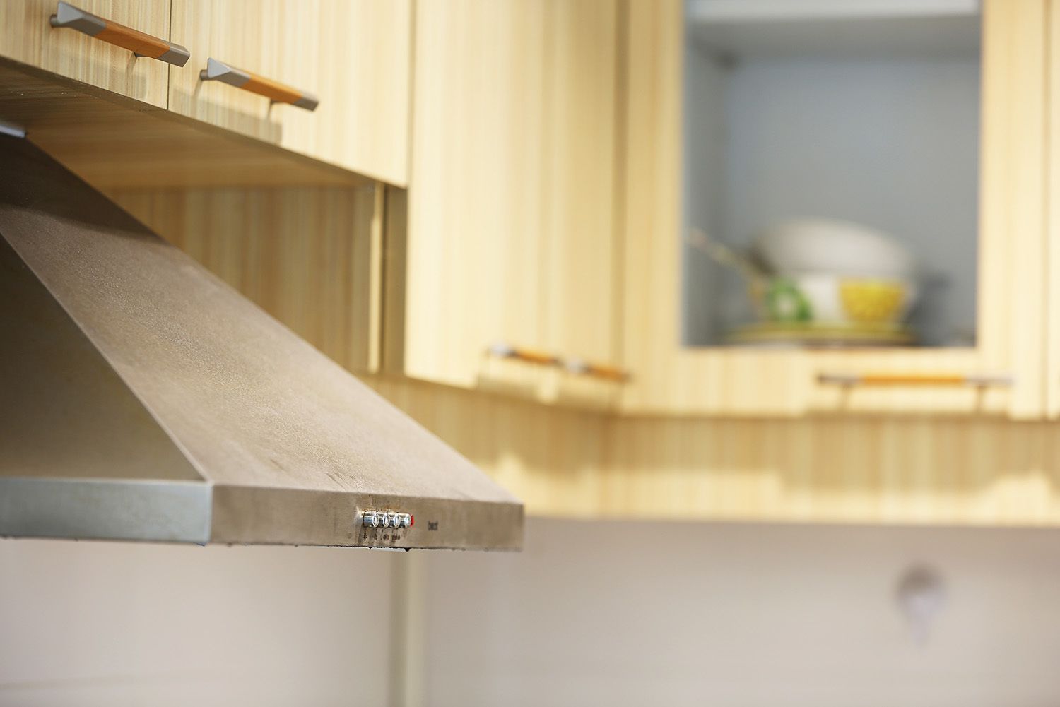 A kitchen with wooden cabinets and a stainless steel range hood.