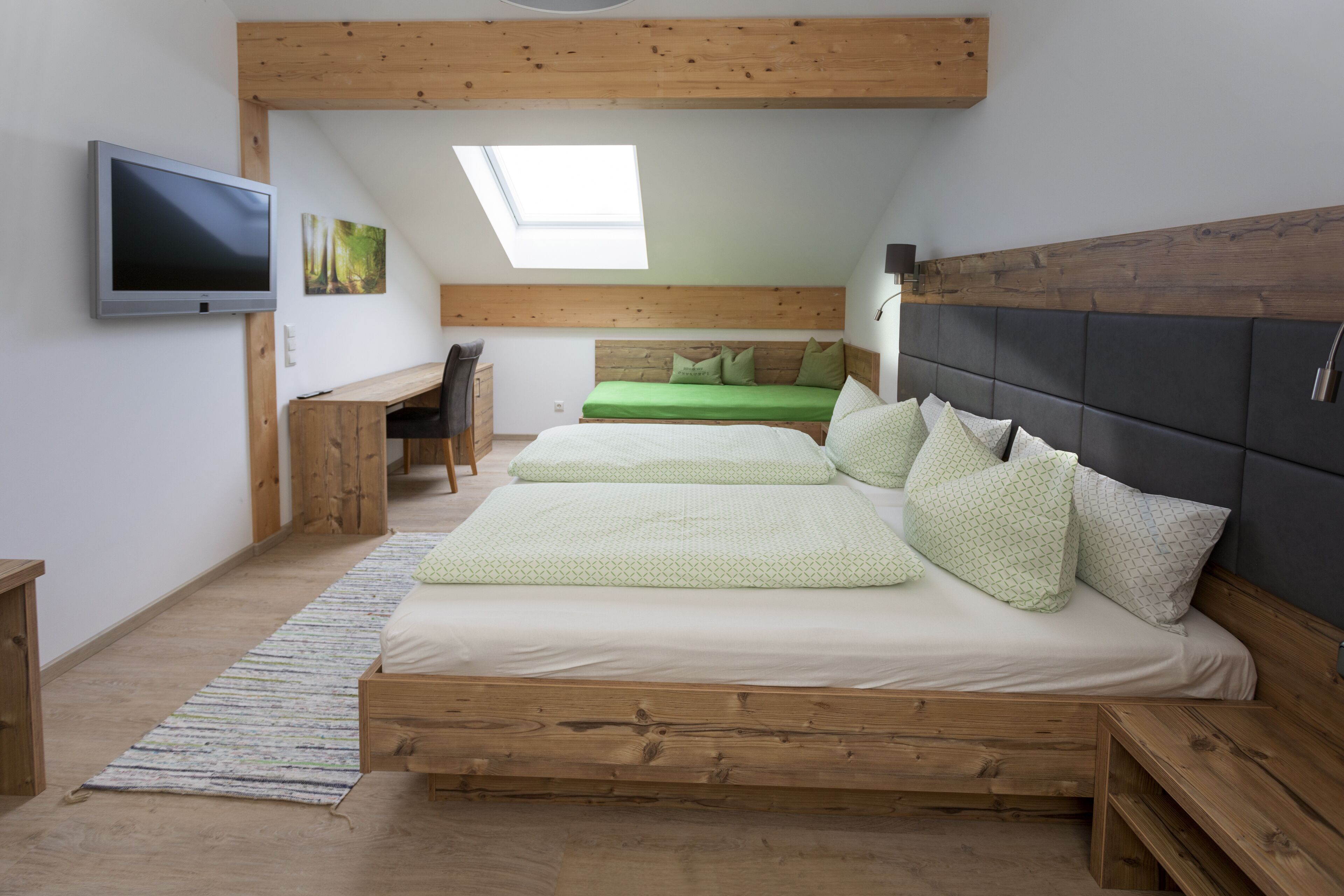 A bedroom with a loft bed, a desk, and a TV.