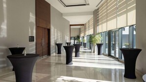 A modern hallway with large windows, potted plants, and a sleek design. - Radisson Blu Hotel Ankara Cankaya (Ankara)