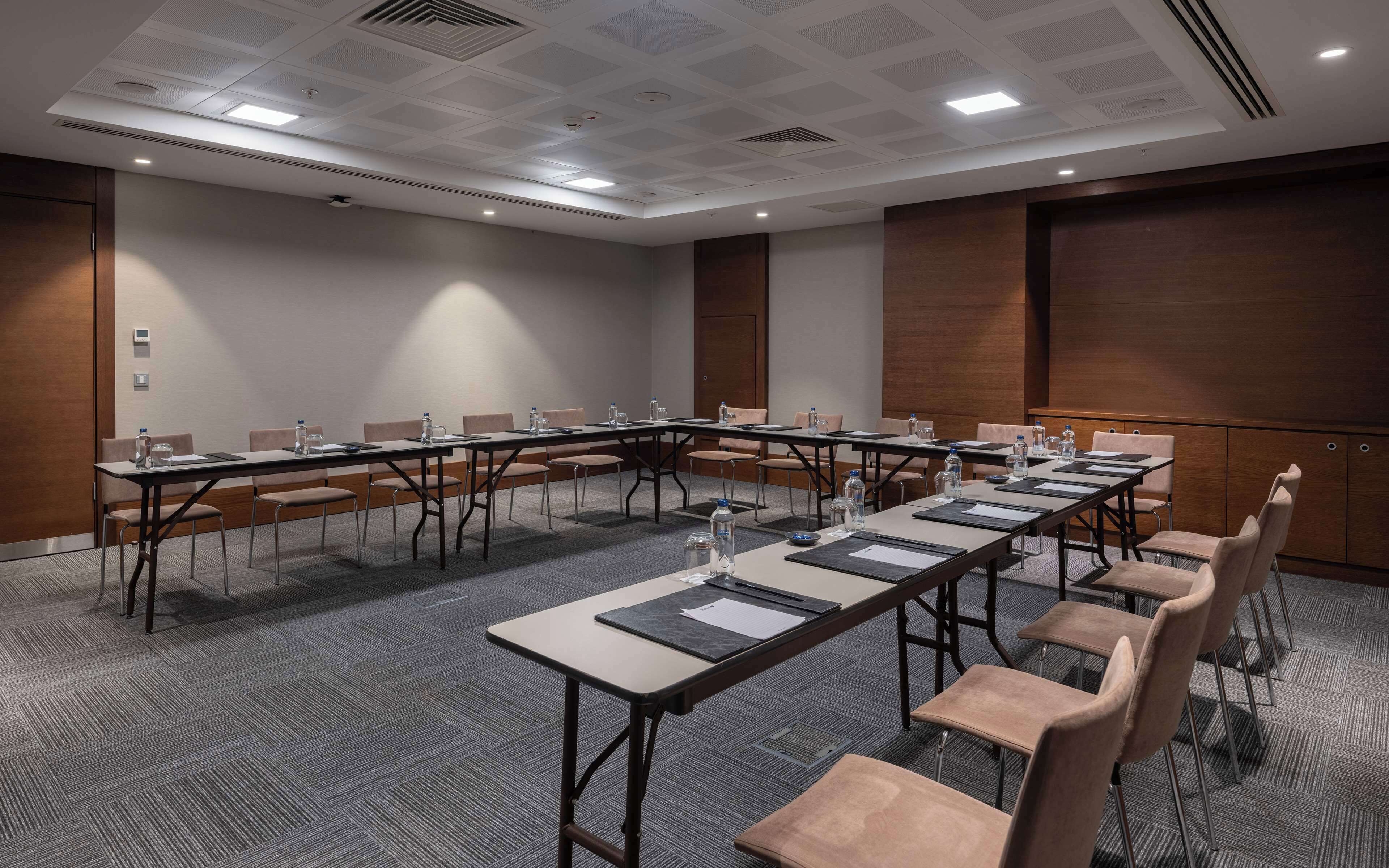 A conference room with a long table, multiple chairs, and water bottles.