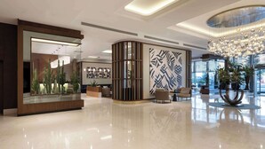 A modern lobby with a glass display of cacti, a patterned wall, and a chandelier. - Radisson Blu Hotel Ankara Cankaya (Ankara)