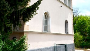 A building with a beige facade, arched windows, and a stone base. - Guesthouse Soul Ljubljana (Ljubljana)