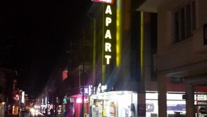 A street view at night with a building featuring a neon sign that reads "MOONLIGHT APART." - Moonlight (Erzincan)