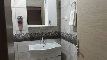 Economy driepersoonskamer, en-suite badkamer | Badkamer | Een douche, een haardroger, pantoffels, handdoeken