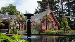 A traditional thatched-roof building with a fountain in the foreground. -  Le Petit Chateau & William de Percy (Newcastle-upon-Tyne)
