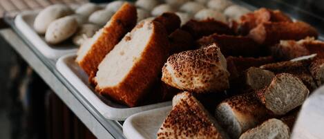 Un bufé con diversas opciones de comida, incluyendo panadería y pasteles.